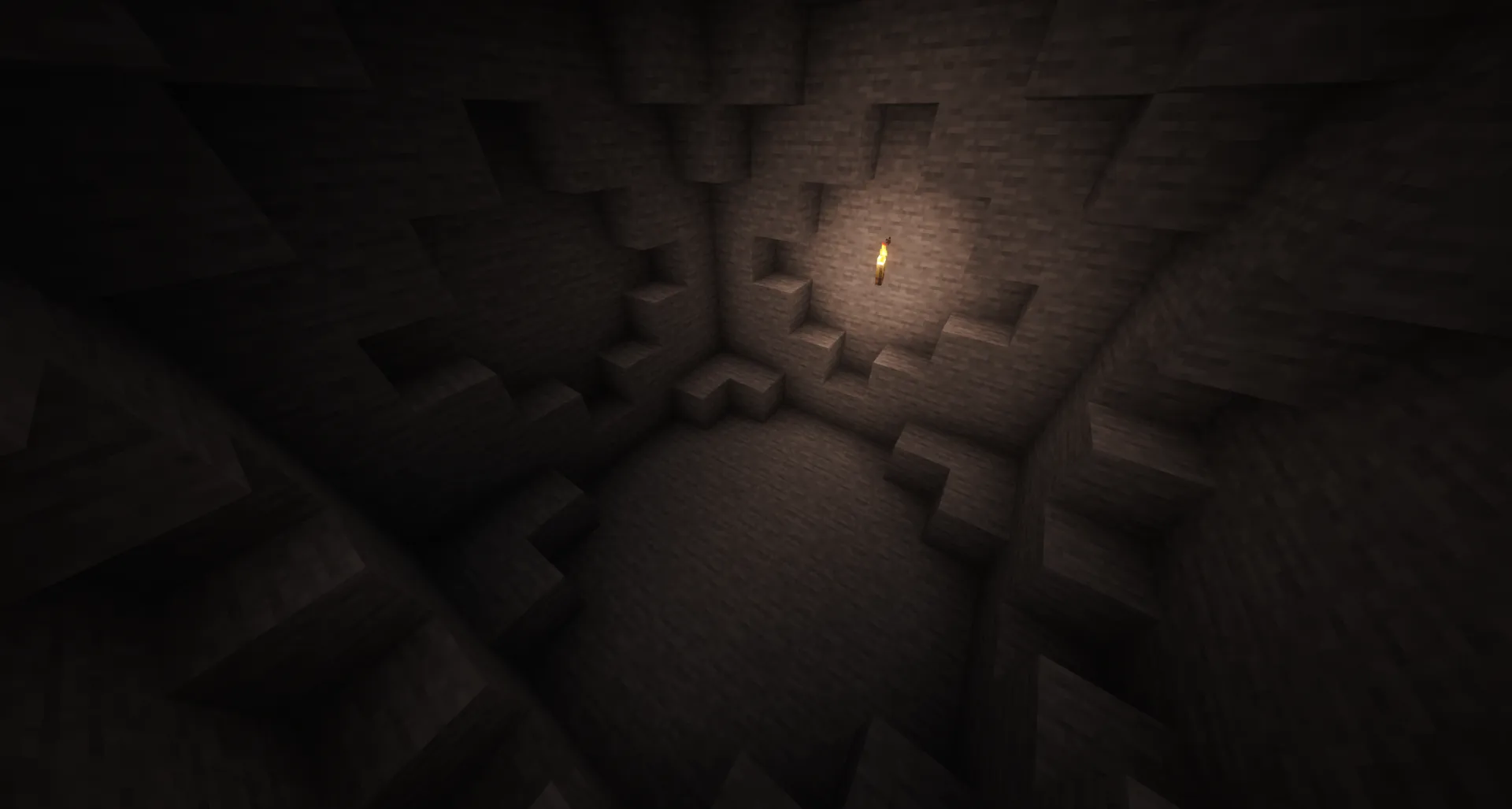 The cave starter: a small dark stone room lit by a single torch on the back wall