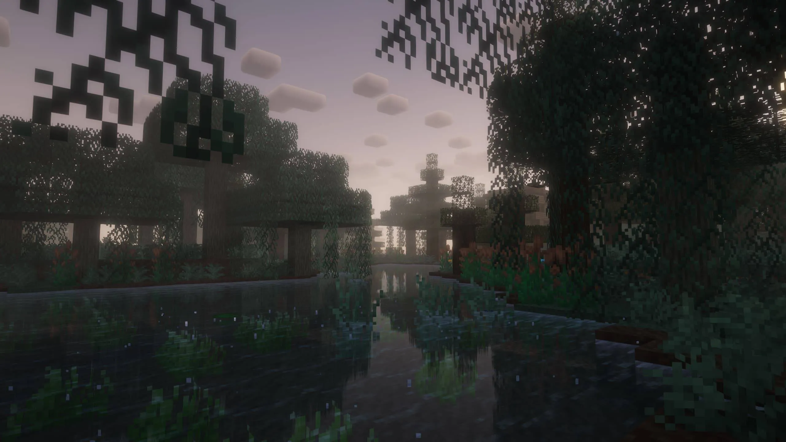 A dim swamp river under hanging-moss trees at dusk, reflecting the pale sky